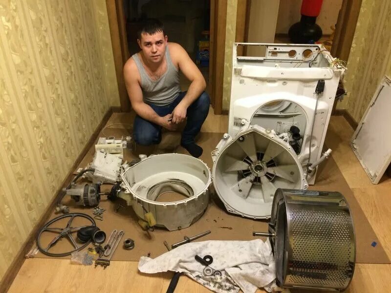 Разбивают стиральную машину. Мастер стиральных машин. Сломалась стиральная машина. Ремонтирует стиральную машину. Починка стиральной машинки.