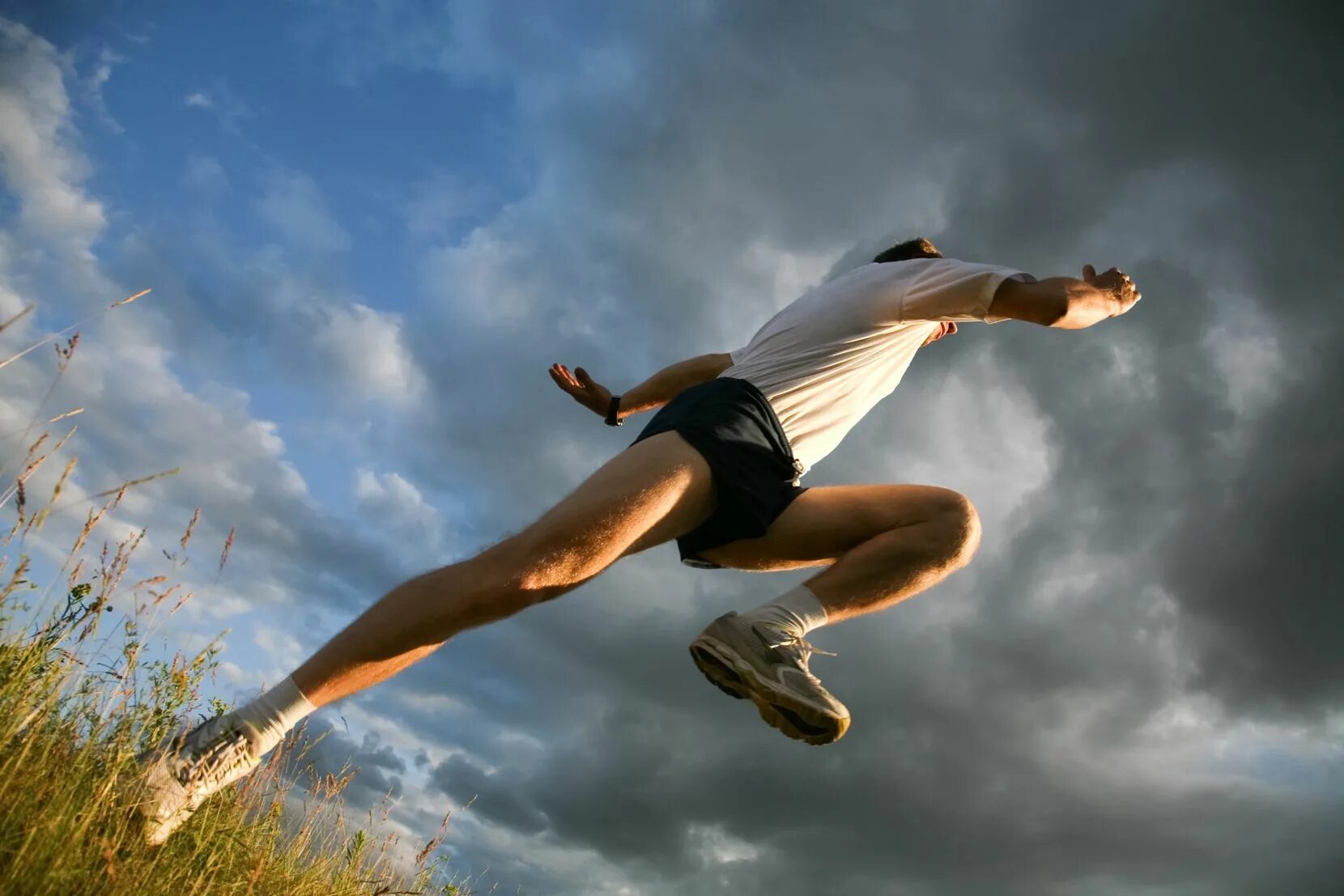 Девушка на фоне стеклянного здания. View from below. View from below. Человек позирует. Trim девочки.