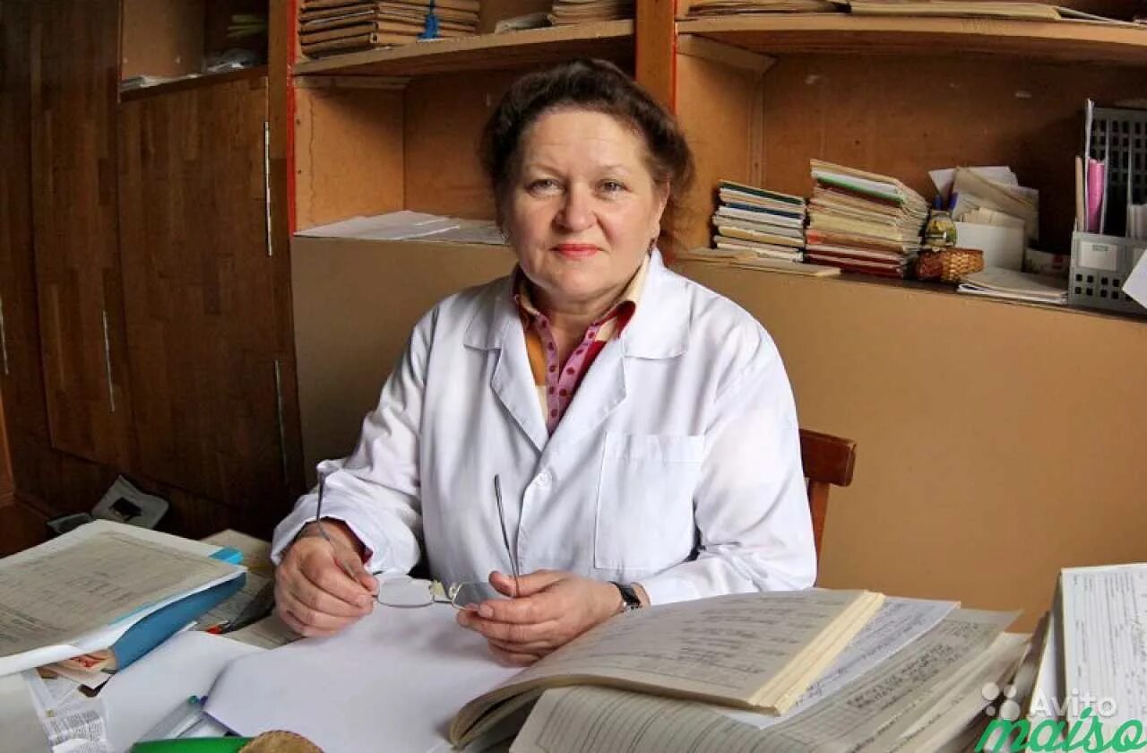 Пожилая женщина врач. Женщина врач за столом. Женщины врачи в России. Женщина врач в кабинете.