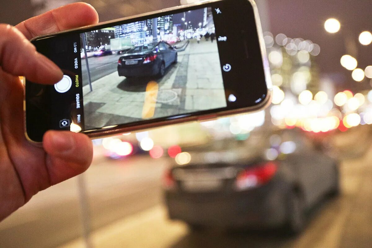 Приложение нарушение правил. Фотографирует автомобиль. фотографирует нарушение пдд. человек фотографирует машину. человек фотографирует на телефон.
