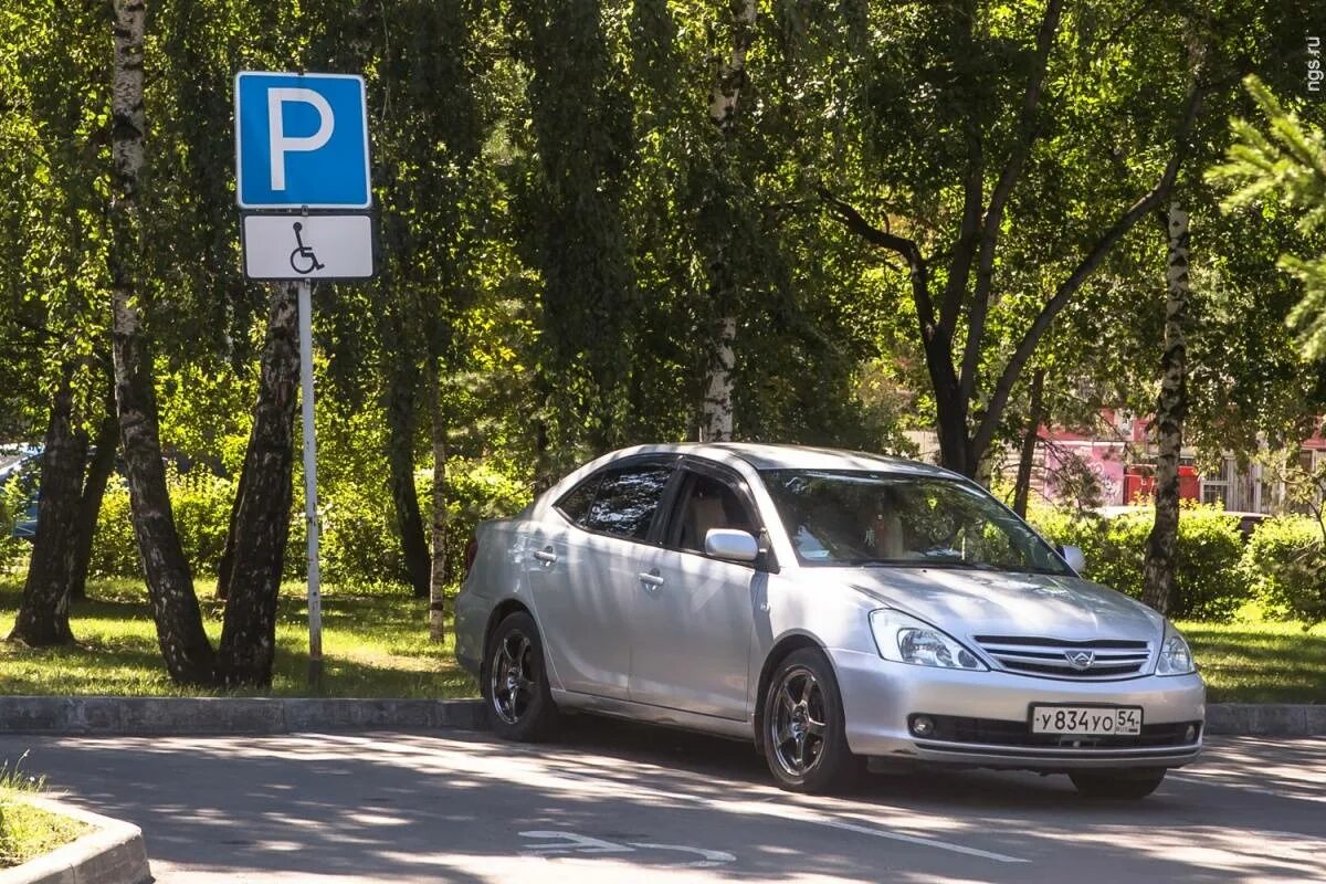 Парковка инвалидов в москве проверить автомобиль. Стоянка автомобилей для инвалидов. машина под знаком парковки. место для инвалидов на парковке. машина на инвалидном месте.