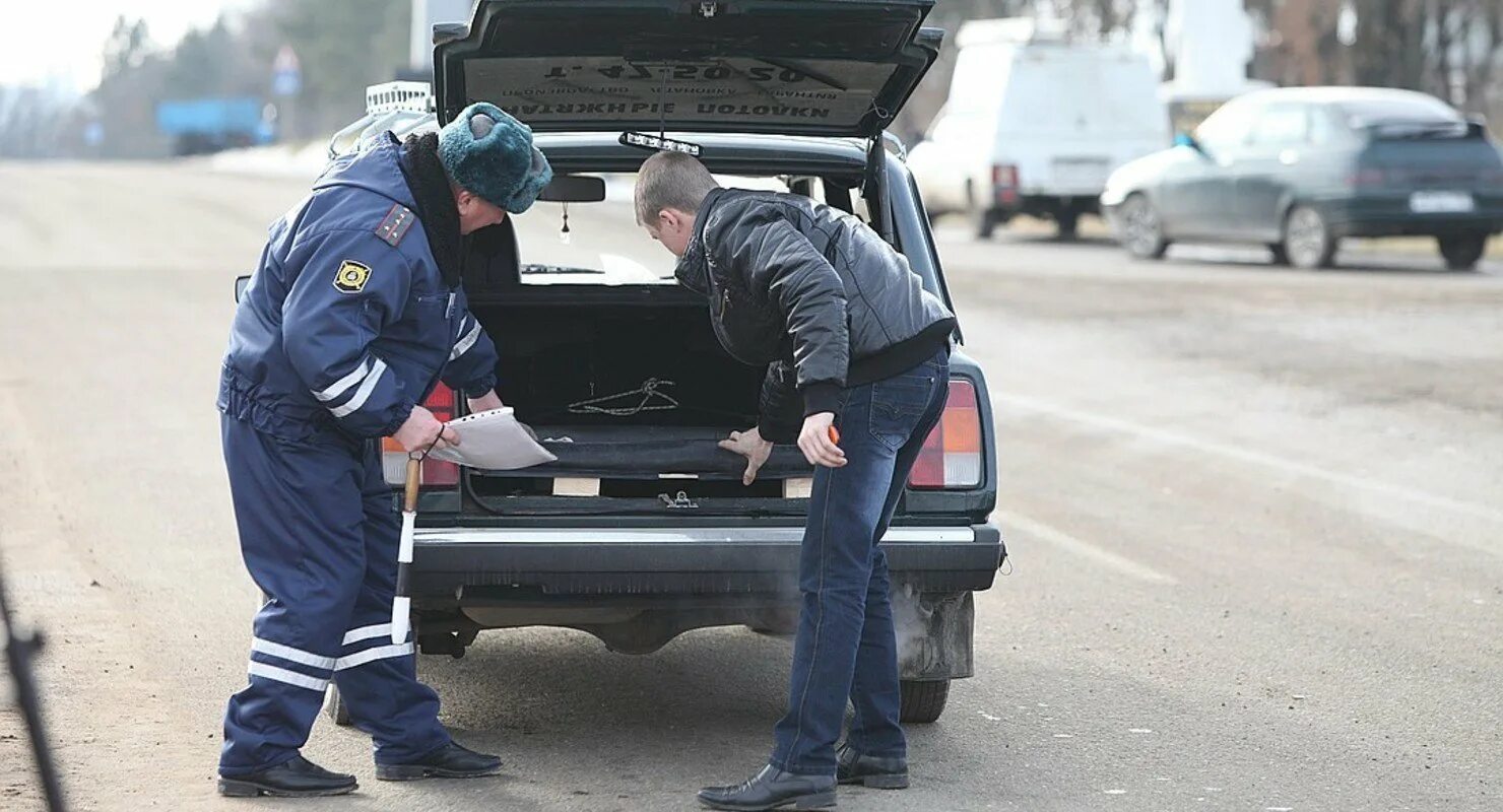 Обыск машины. Досмотр транспортного средства. Гаишник осматривает машину. Осмотр машин в ГИБДД. Материалы дпс