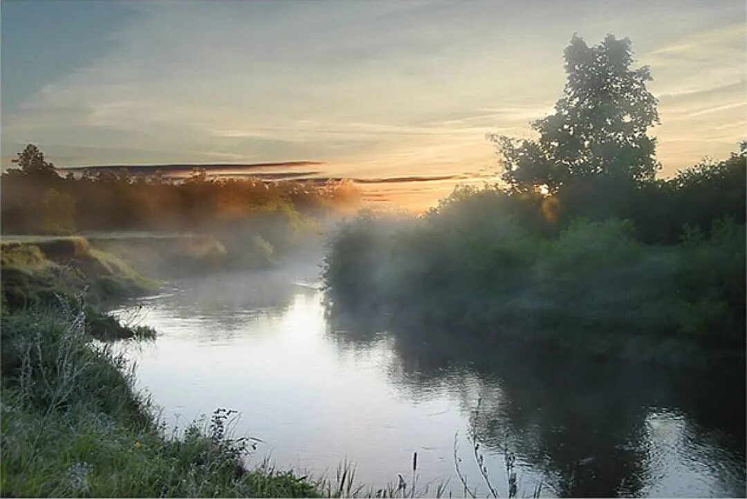 Глубокая тихая вода лакированно блестела словно. Рассвет на реке. Красивый пейзаж. Утренняя река. Рассвет над рекой.