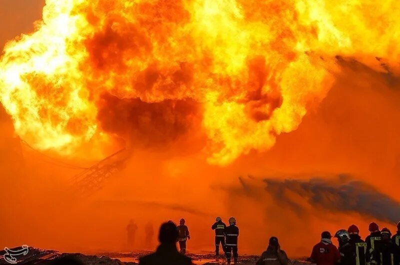 Человек на фоне пожара. Средство тушения пожара на нефтяных полях на базе танка т-34. Море горит. Война в персидском заливе 1991. Сжигание нефти.