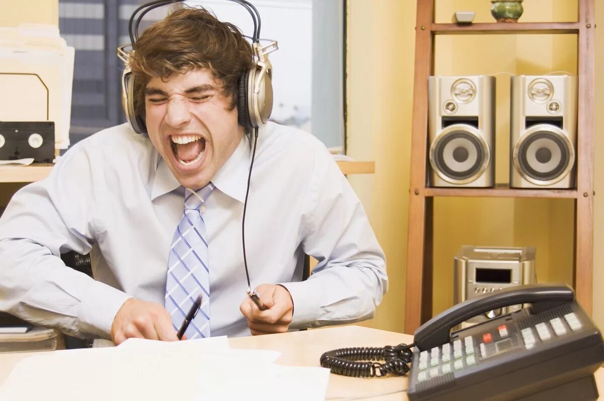 Музыка послушать радио. Человек в наушниках. Человек слушает музыку. Человек слушает музыку на работе. В наушниках в офисе.