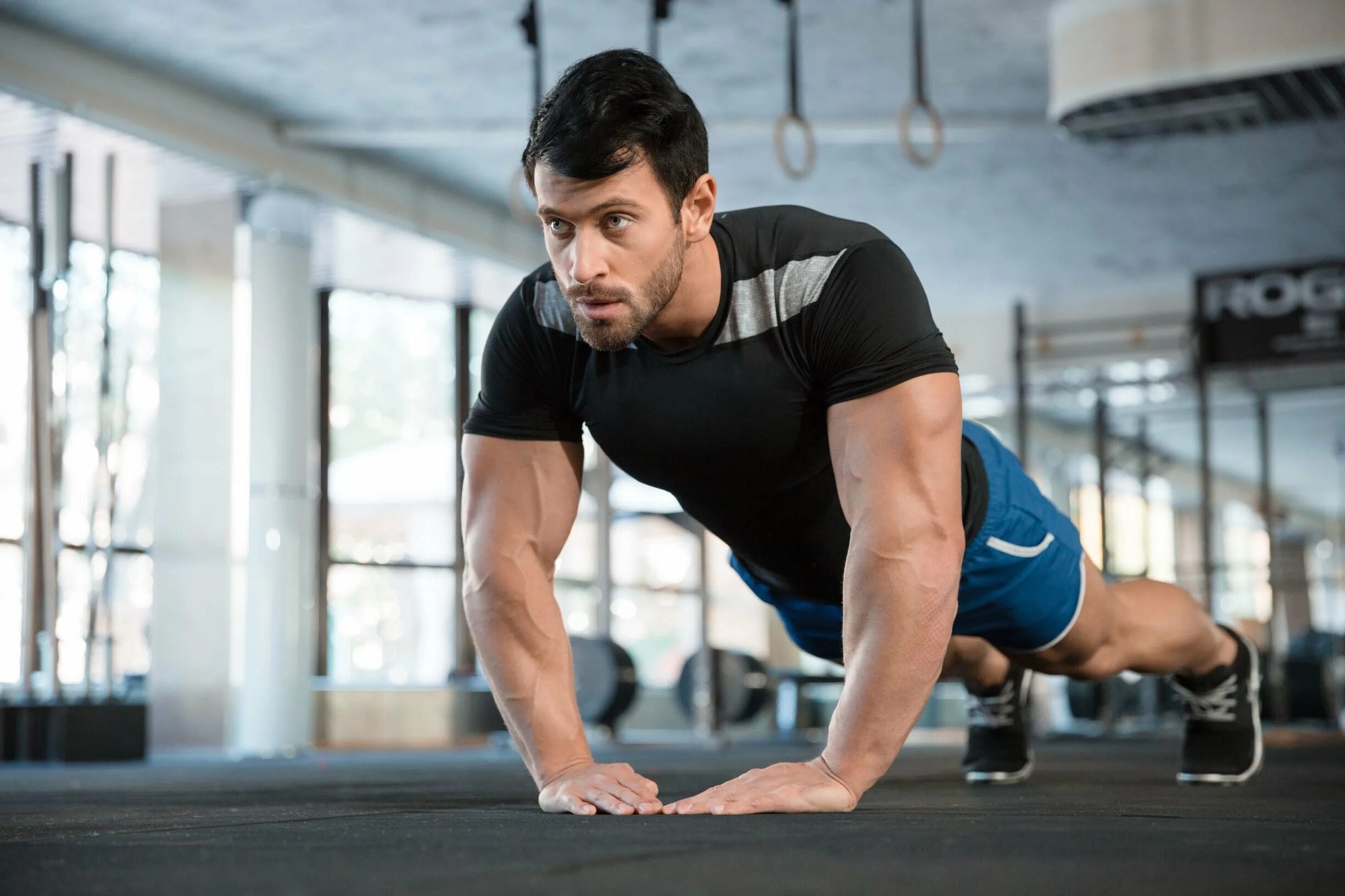 Спортсмены. Спортсмен тренируется. Хорошая физическая форма. Отжимания в спортзале. Более сильный спортсмен