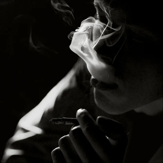 Дымом печали. Курящий в темноте. Парень курит в темноте. Парень с сигаретой в темноте. Грустный человек с сигаретой.