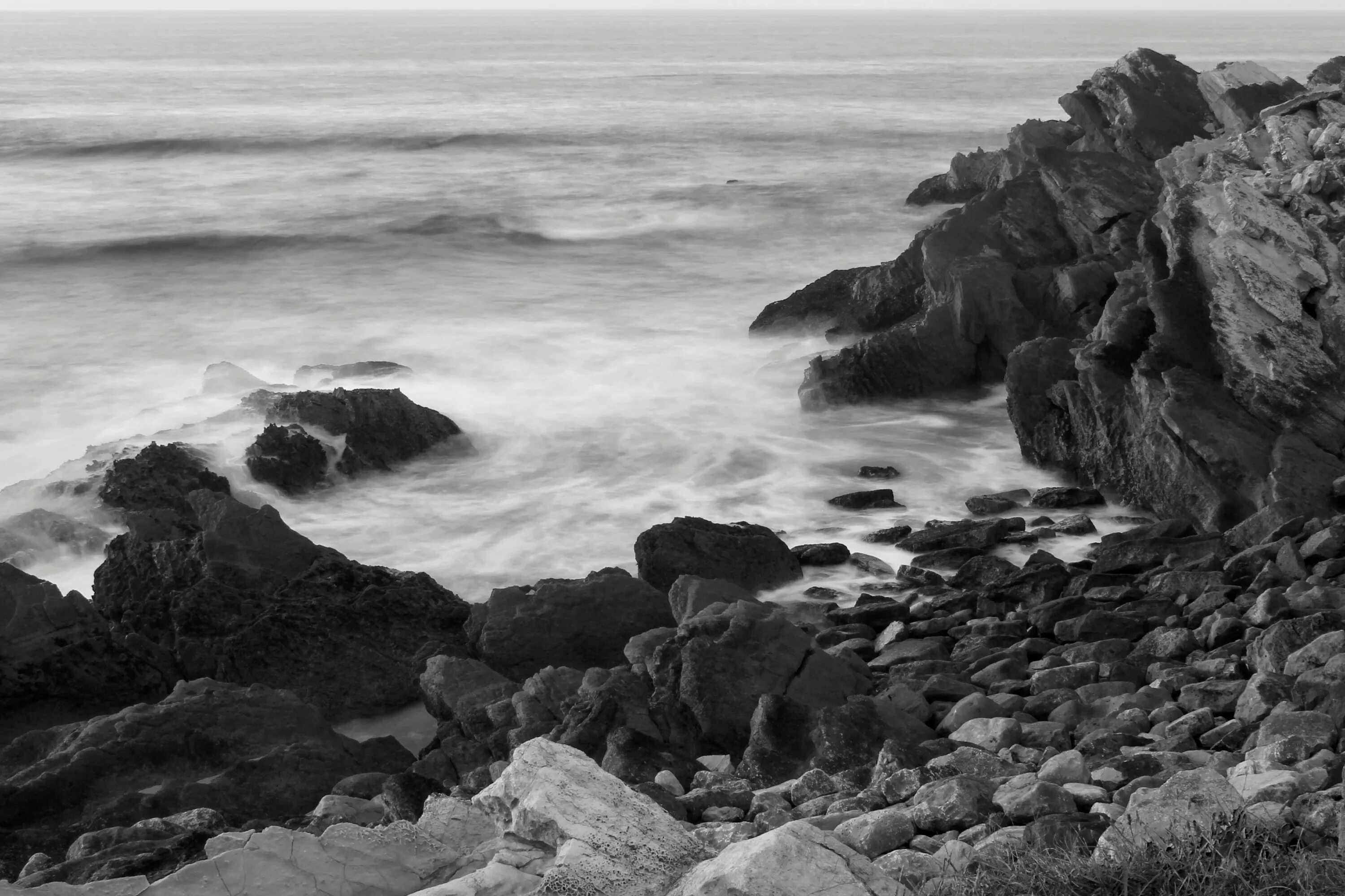 Черно белый океан. Море черно белое. Природа море. Каменистый пляж.