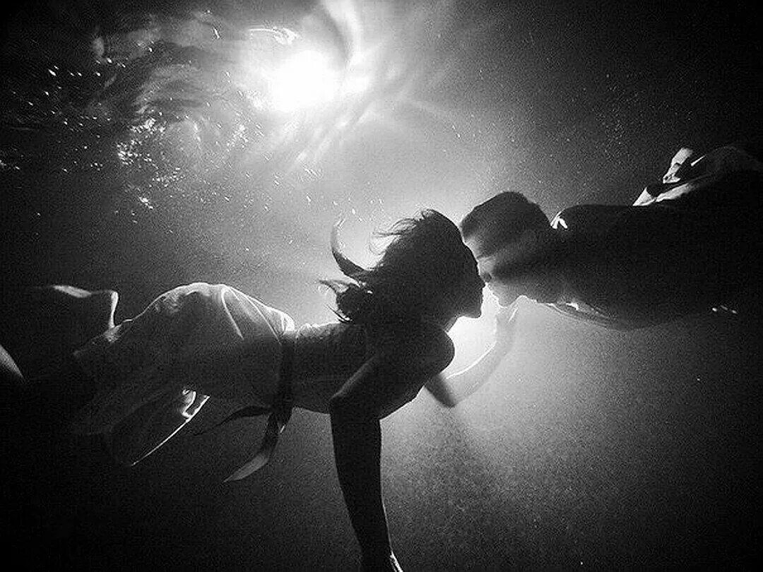 Мужчина и женщина под водой. Влюбленные под водой. Парень и девушка в воде. Подводная фотосессия. Тонущая в темноте