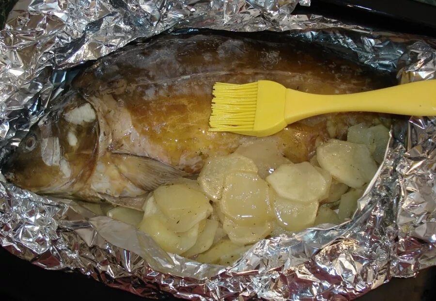 Рыба фольге в духовке сколько минут. Рыба запеченная в фольге. Рыба запечённая в духовке в фольге. Рыба с картошкой в духовке в фольге. Толстолобик в духовке в фольге.