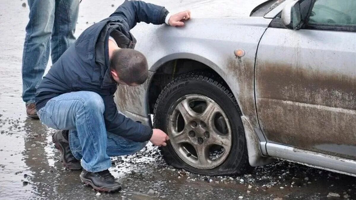 Пробил колесо на дороге. Автомобиль попал в яму на дороге. Пробитое колесо. Сломалось колесо у машины.