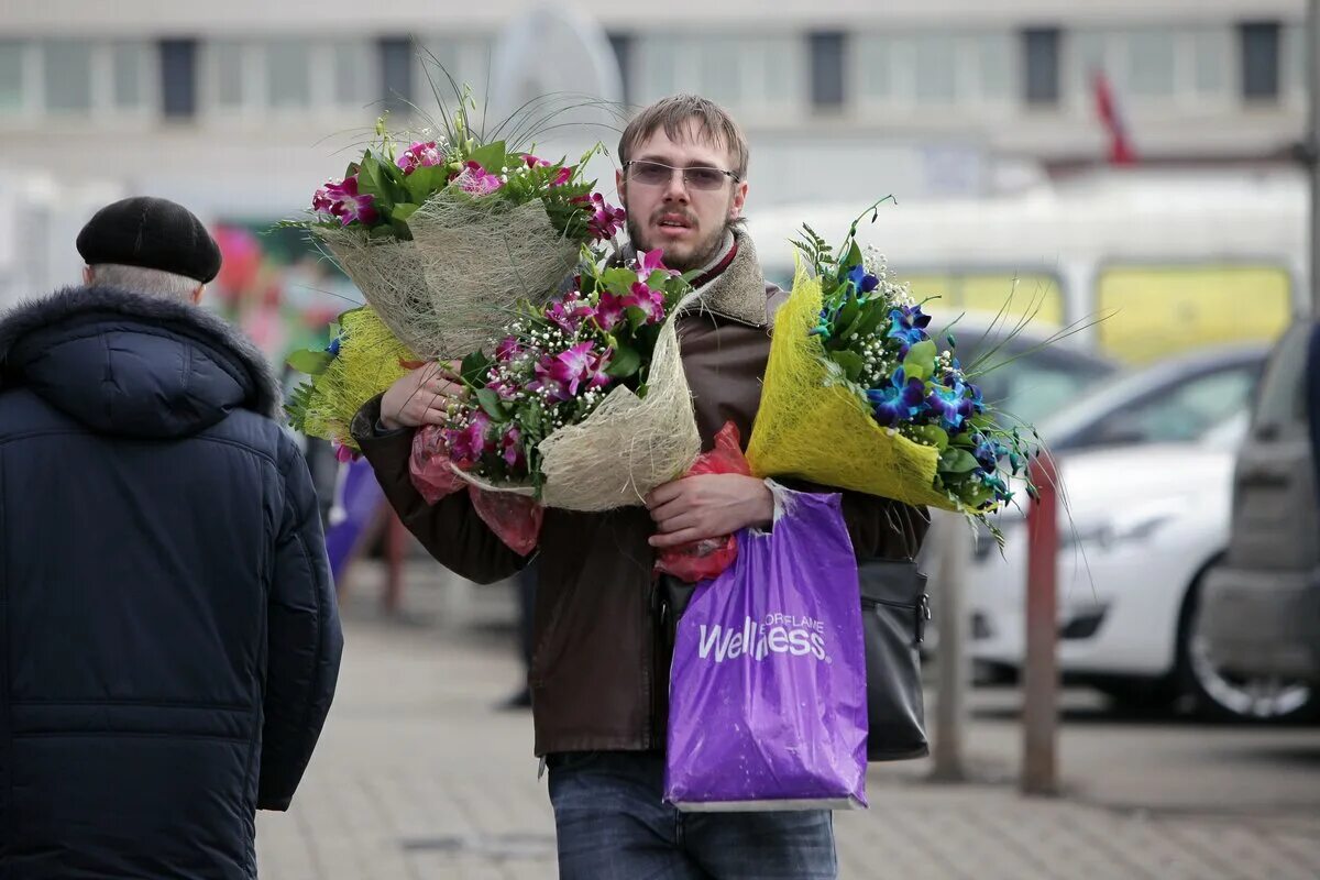 Парень с цветами. Дарит цветы. На улице дарят цветы