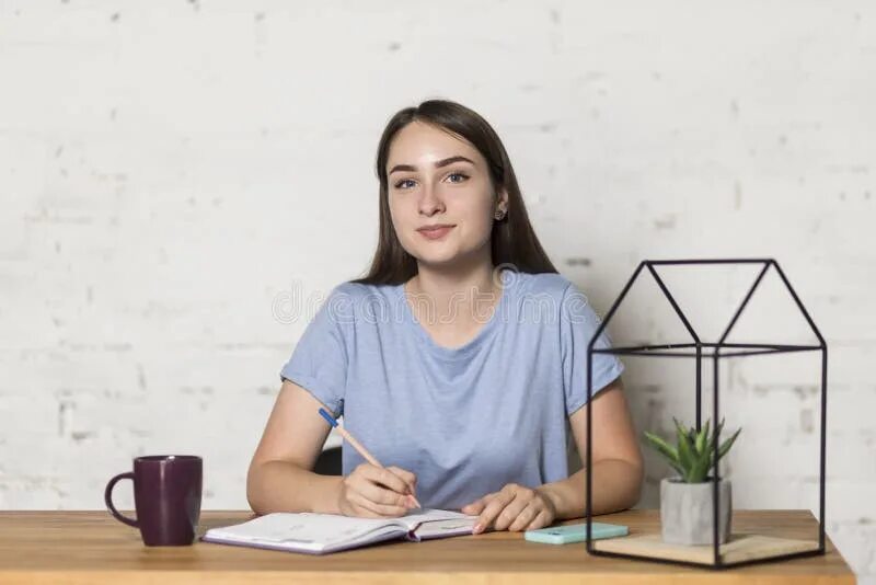 She is sitting at the table. Девушка сидит за столом руки на столе перед ней. Девушка, сидя за столом отгораживаясь ладонью. Люди сидят за столом смотря в камеру. Девушка за столом смотрит вверх.