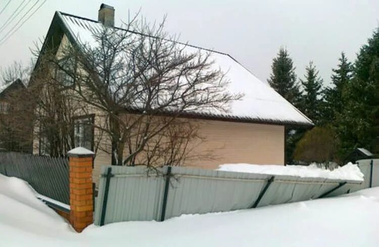 Усиленный забор от снега. Зимний дом кровля забор. Забор от снега с крыши. Снег с крыши на забор.