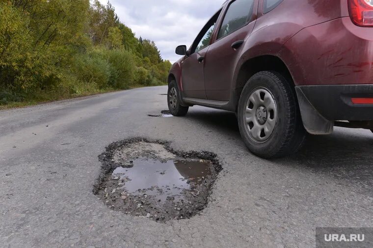 Колесо попало в яму на дороге. Ямы на дороге и автомобиль. Яма для автомобиля.