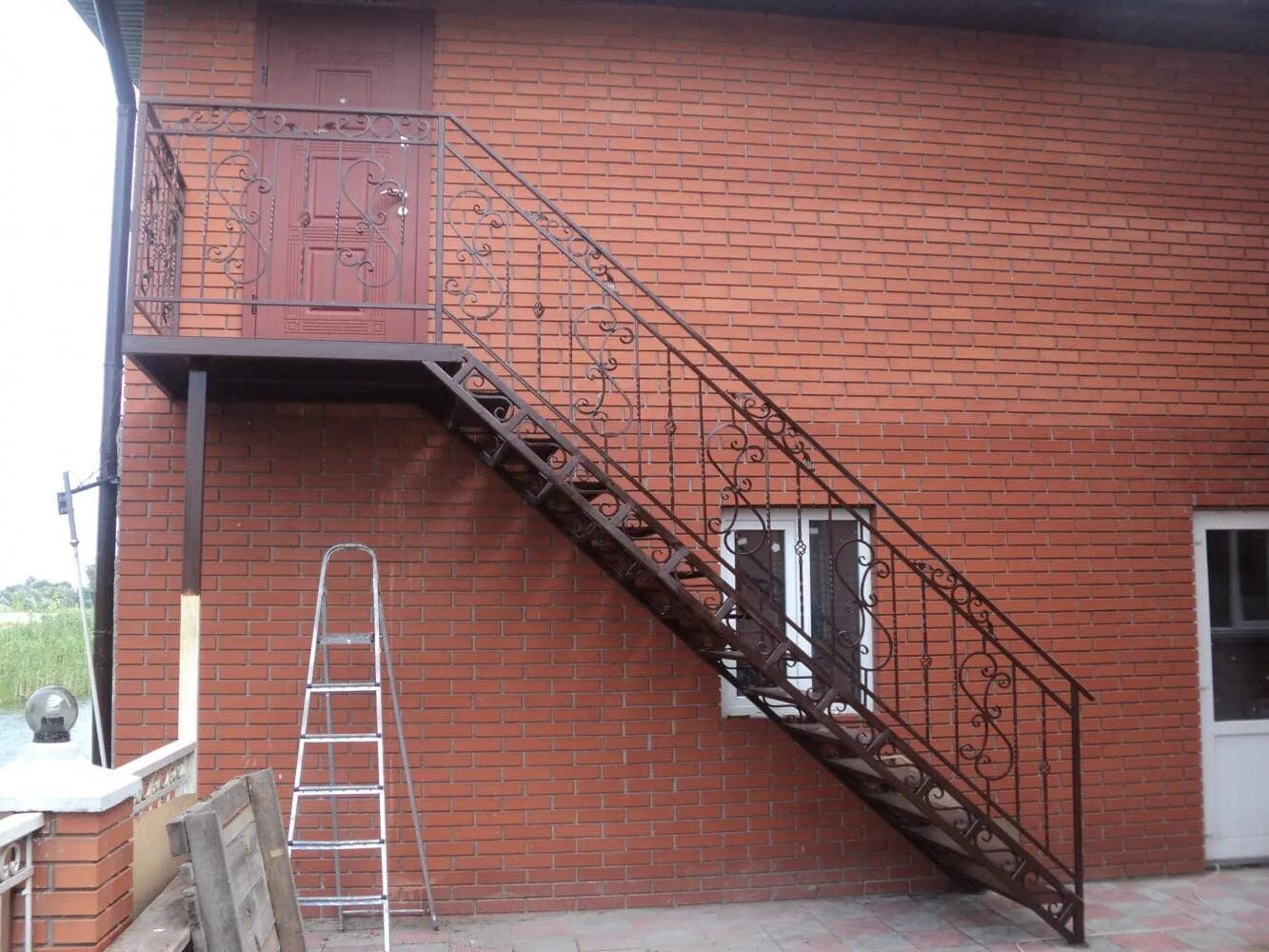 Уличная лестница второй. Наружная металлическая лестница. Наружная лестница на второй этаж. Лестница наружная металлическая на второй этаж. Железная лестница на второй этаж наружная.