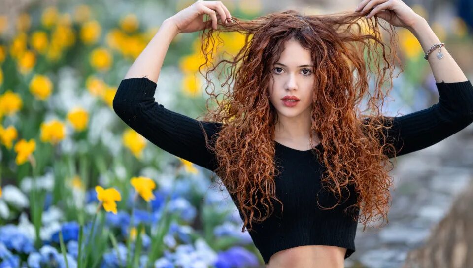 Кудрявая рыжая девушка с длинными ножками 