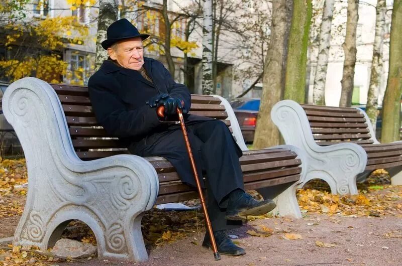 Еще вовсе человек не пожилой. Старик на скамейке. Старик на скамейке в парке. Пенсионеры на лавочке в парке. Люди на лавочке.