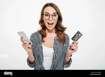 Portrait of a satisfied casual girl holding mobile phone and showing credit...