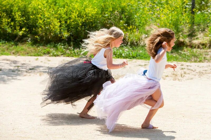 Две девушки убегают. Две девушки убегают. Две девушки бегут смешные. Девочки кружатся за руки. Дети бегают в деревне.