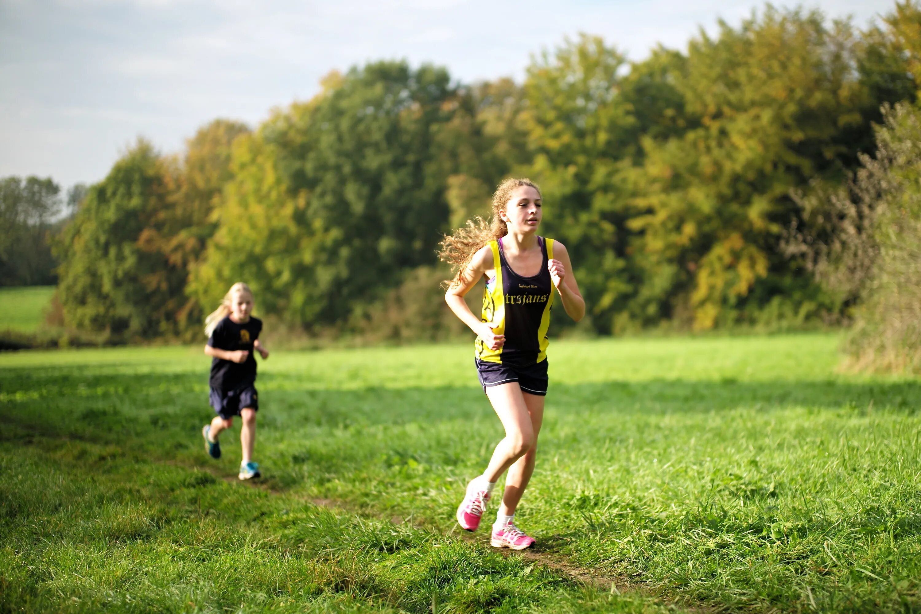 Спортивные девочки. Бег трусцой. Бег в медленном темпе для детей. Спортивные девушки на траве. Running field