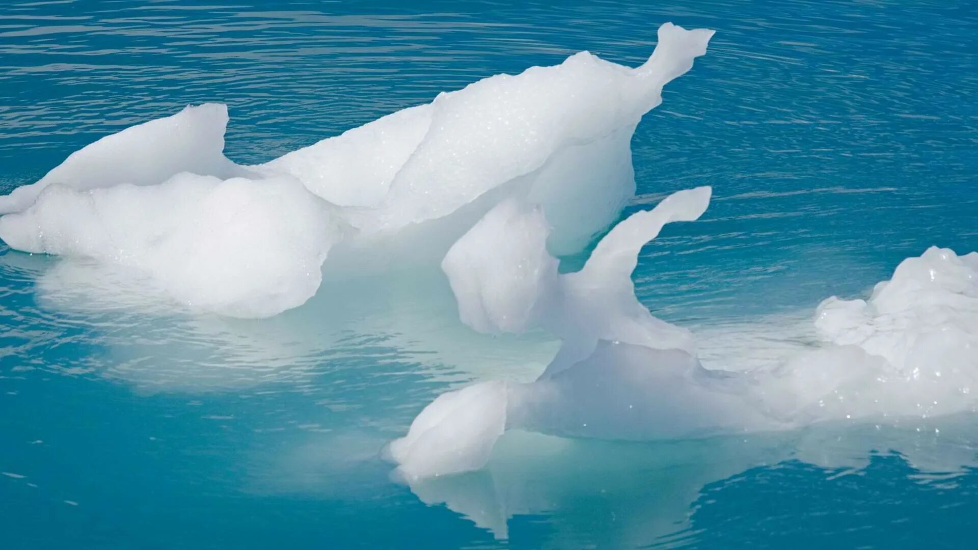 Кусок льда плавает на поверхности воды. Вода со льдом. Льдины плывут. Плавающие льдины. Лед плавает в воде.