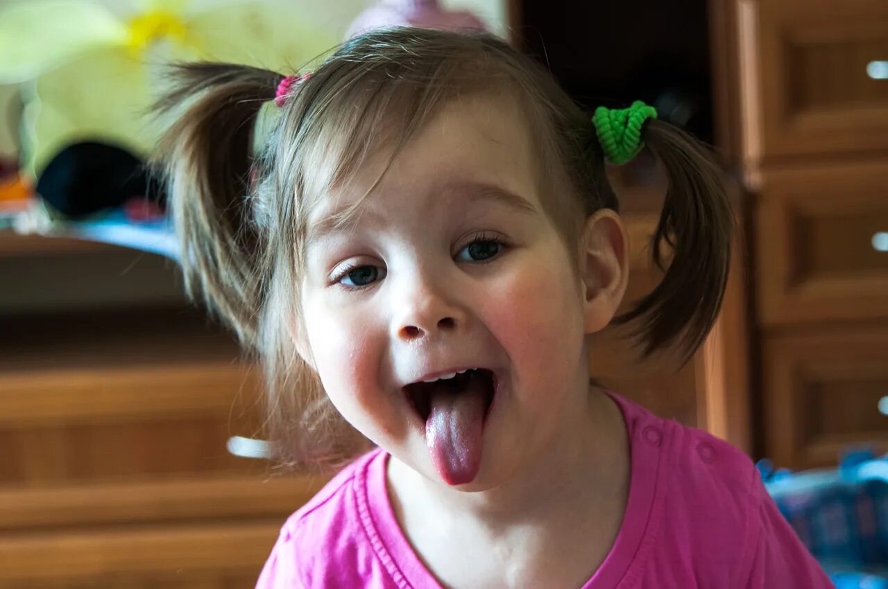 Девочка с языком. Ребенку год с рождения с высунутым языком. Младенец высовывает язык. Почему ребенок в 7 лет во сне жует язык. Ребенку 5 лет высовывает язык.