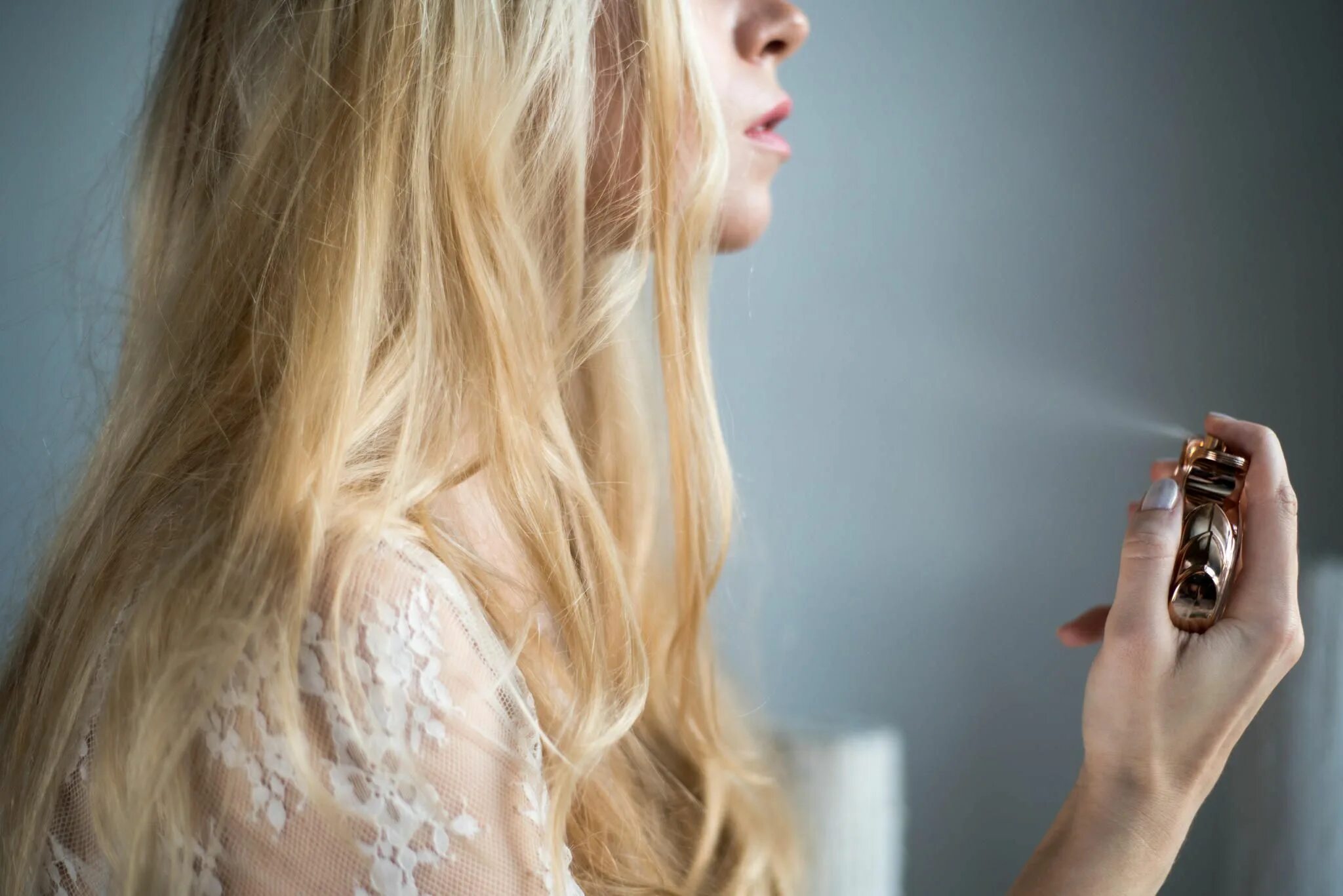 Красивая девушка с духами. Распыление парфюма. Шлейф духов это. Девушка вдыхает аромат. Парфюм для женщин.