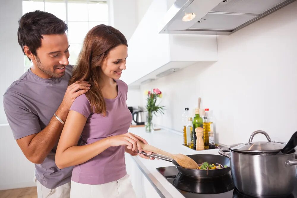 Пока жена готовит муж. Муж обнимает жену на кухне. Жена готовит. Муж и жена готовят. Пара на кухне.