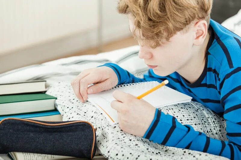Doing his homework. Мальчик прописывает. делаем уроки лежа. boy doing his homework. обои на телефон для подростков делай уроки.