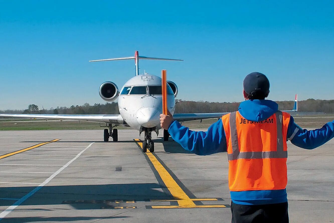 Регулировщик в аэропорту. Самолет на рулежке. руление самолета. рулежка в аэропорту. регулировщик на взлетной полосе.