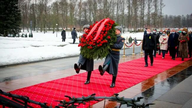 Освобождение блокады 2024. Пискаревское кладбище блокада Ленинграда. Вечный огонь на Пискаревском кладбище. Возложение цветов на Пискаревском кладбище 27 января 2022. День снятия блокады Ленинграда 27 января Пискаревское кладбище.