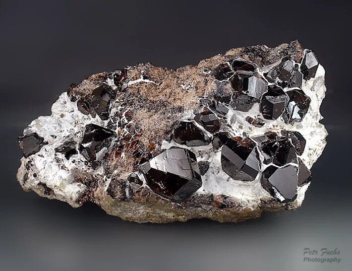 Оловянная руда касситерит. Касситерит оловянный камень. Касситерит камень минерал. Минерал олова касситерит.
