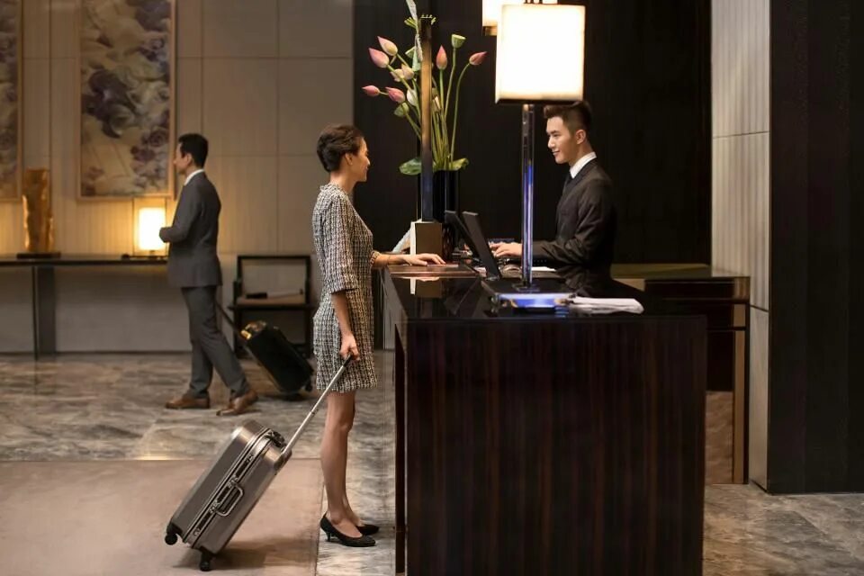 Checking into a Hotel. Checking in at a Hotel. The Receptionist leads the pair into the Room. Check in at the hotel