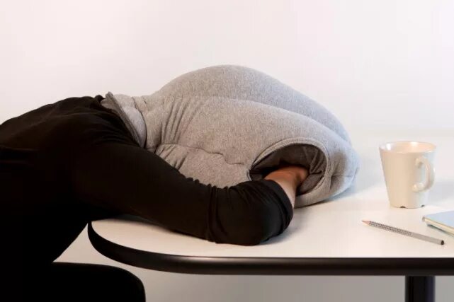 Хочется спать на работе как взбодриться. Подушка-страус Ostrich Pillow. Подушка для сна на обеде. Офисная подушка для сна. Подушка для сна на столе в офисе.