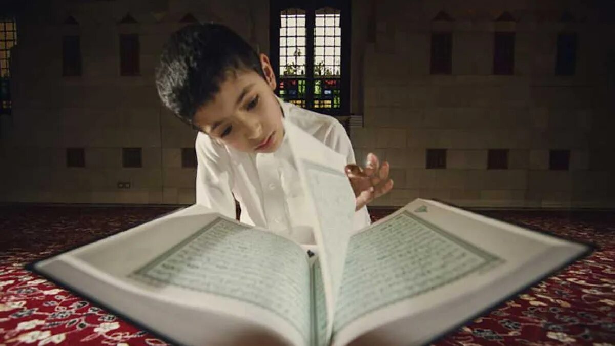 Читаем коран медленно. Человек с Кораном. Чтение Корана. Мальчик с Кораном.