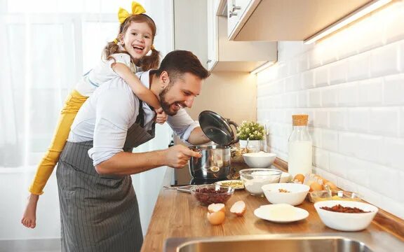 Дочки дают отцам на кухне после приготовления пищи