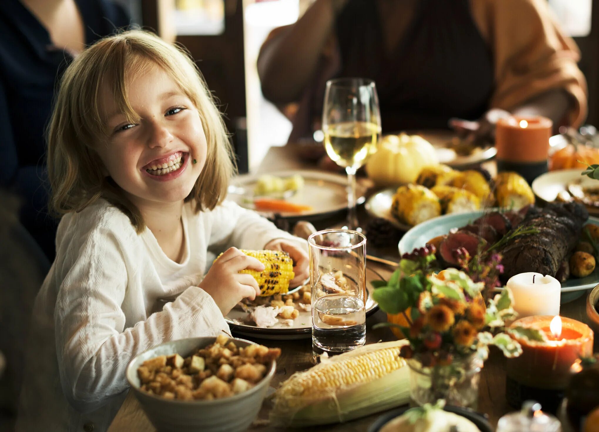 Еда развлечения. Еда как развлечение. Семья ест кукурузу за столом. Ребенок ест кукурузу. Girl eat Corn.