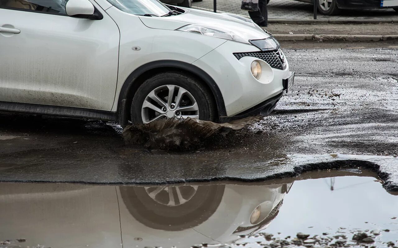 Машина попала в яму на дороге. Автомобиль попал в воду