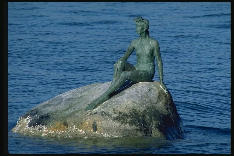 Ариэль newtort. Русалочка на камне. Памятник русалочке в санкт-петербурге. Русалочка ариэль сидит на камне. Мультик русалочка дисней 1989.