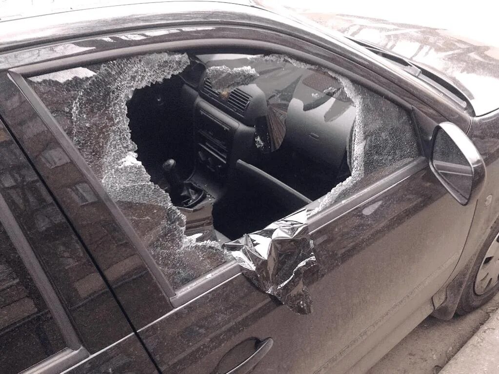 Разбили окно машины. Разбитое боковое стекло автомобиля. Машина с разбитым стеклом. Разбитое окно машины. Разбили стекло в машине.