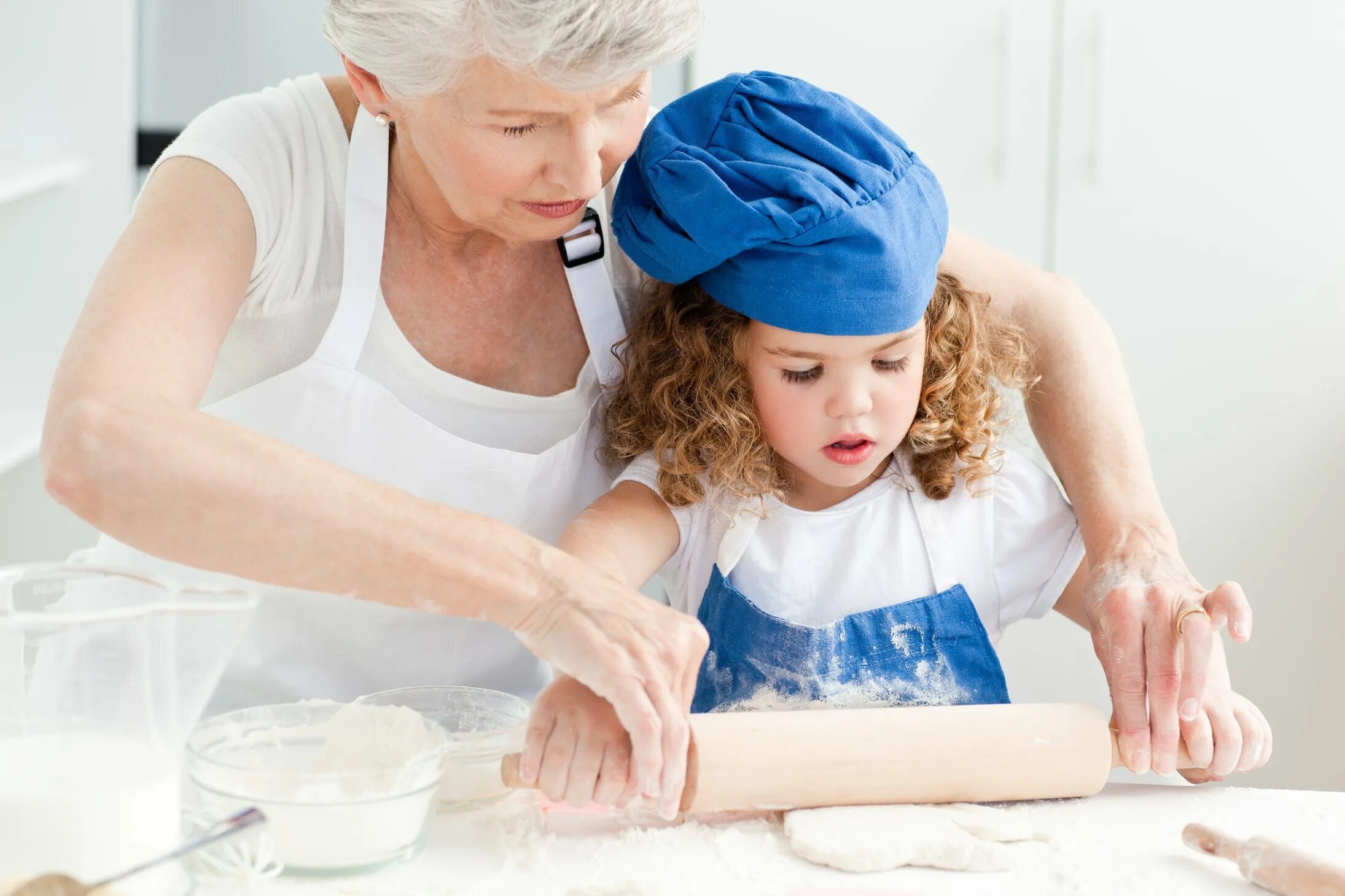 Русская мама помогает. Бабушка и внучка готовят. Бабушка учит готовить. Бабушка с внучкой на кухне. Мама и бабушка готовят.