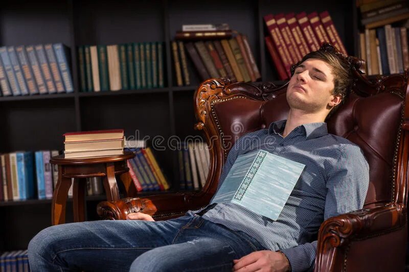 Читать книгу и спать. Мужчина в кресле с книгой. Мужчина в библиотеке.