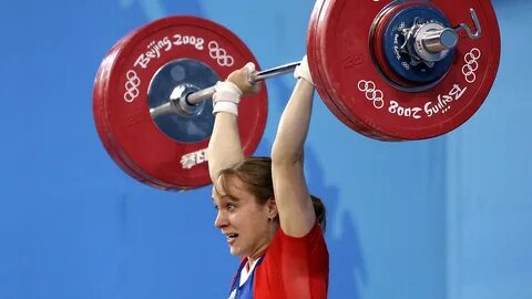 Спортсмены по тяжелой атлетике поднимают штангу