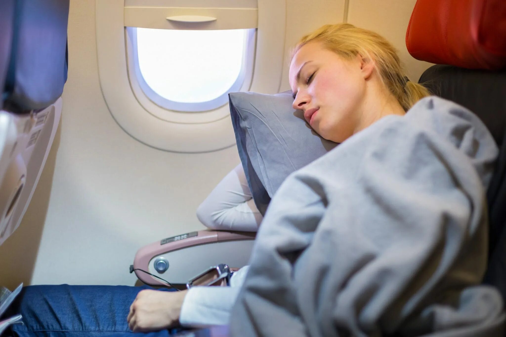 Девушка в самолете. Спящий в самолете человек.