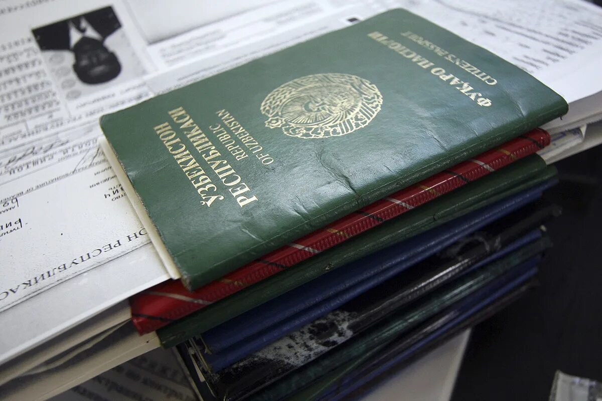 Стопка паспортов мигрантов. Иностранные документы. Фиктивная постановка на учет иностранного гражданина. Незаконная регистрация.