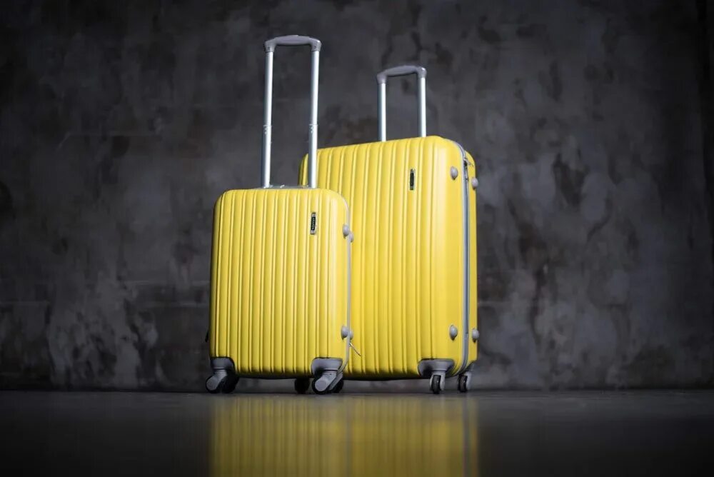 Чемодан фото. Чемоданы пластиковые неубиваемые. Неубиваемый чемодан на колесах. Живой чемодан. Чемодан на желтом фоне.