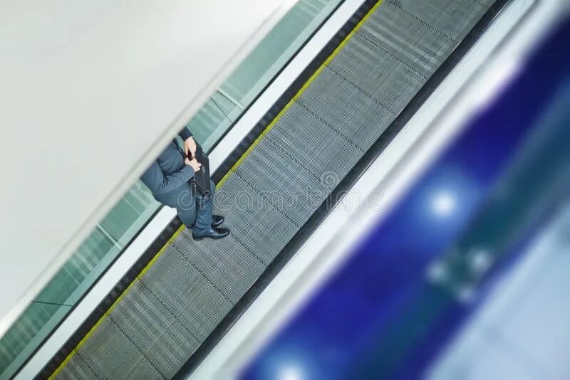 Эскалатор метрополитена поднимает стоящего. Люди на эскалаторе. Бизнесмен на эскалаторе. Эскалатор и Деловые люди. Эскалатор со стоящим на нем человеком.