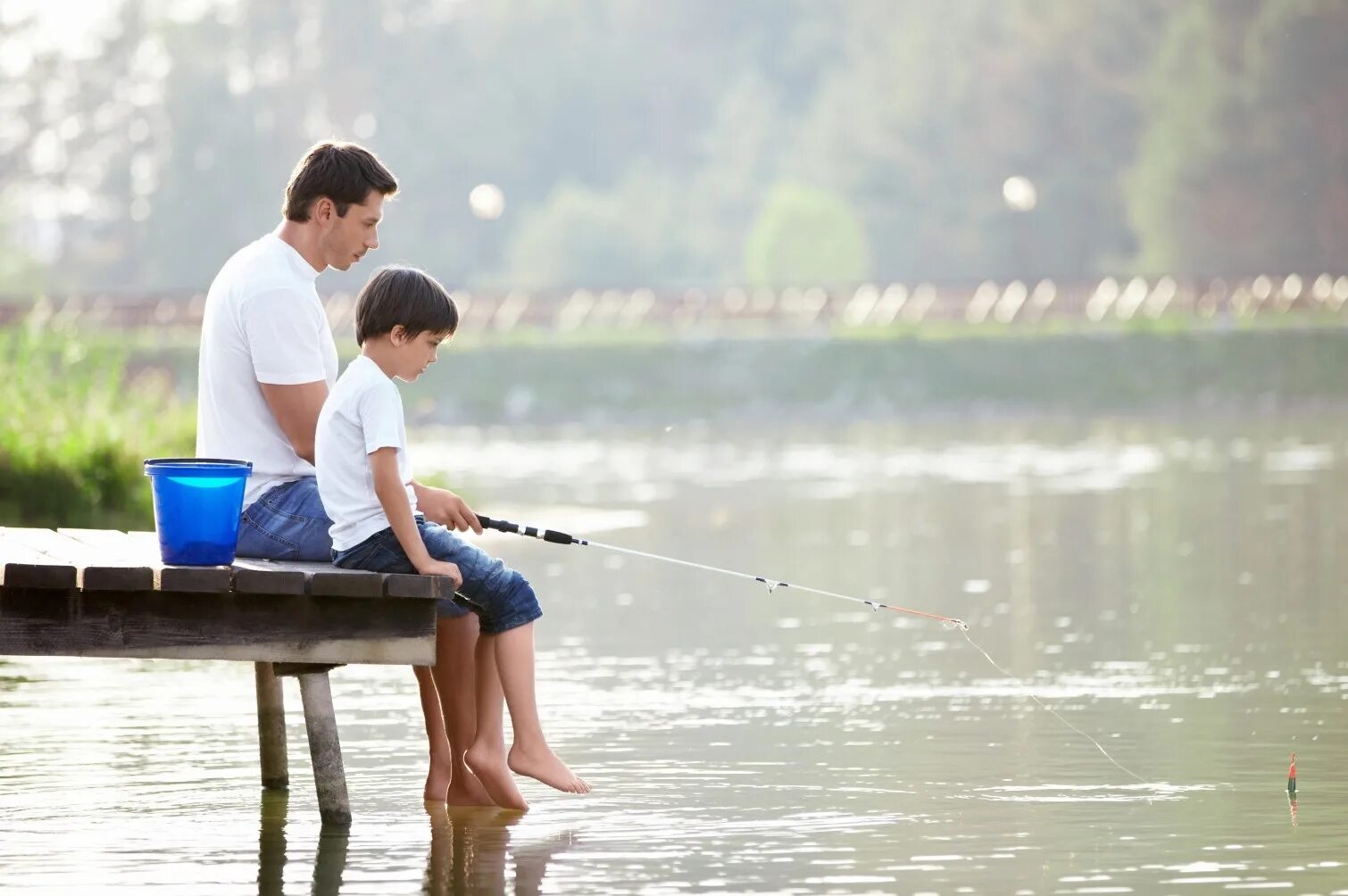 Лов детьми. Идеальная жизнь. Семья у реки. Отец и сын на рыбалке. Семья на озере.