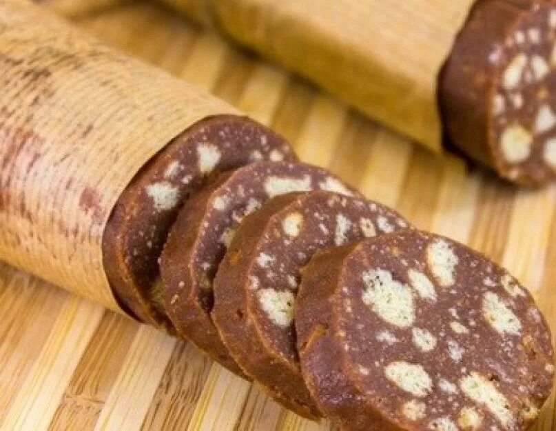 Колбаса из печенья со сгущенкой и какао. Шоколадная колбаска. рулет из печенья. рулет из печенья колбаска. шоколадный рулет из печенья.